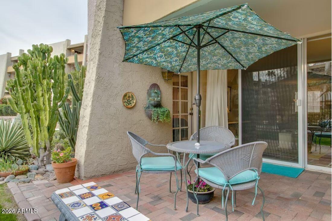 7625 East Camelback Road, Unit B117 Scottsdale, AZ 85251 - Photo 4 of 27 a patio with a table and chairs under an umbrella