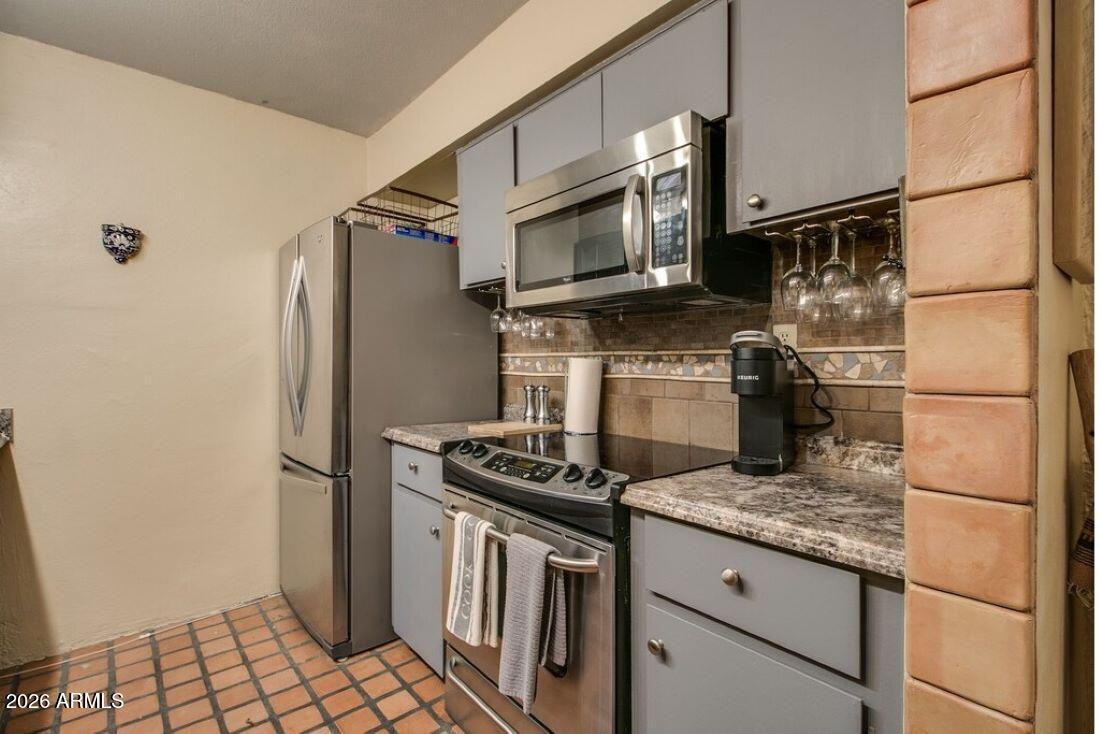7625 East Camelback Road, Unit B117 Scottsdale, AZ 85251 - Photo 5 of 27 a kitchen with stainless steel appliances granite countertop a stove a refrigerator and a refrigerator