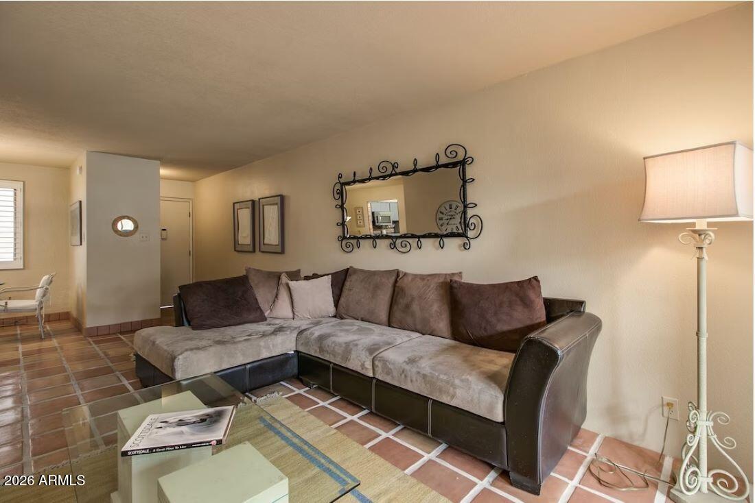 7625 East Camelback Road, Unit B117 Scottsdale, AZ 85251 - Photo 6 of 27 a living room with furniture and a lamp