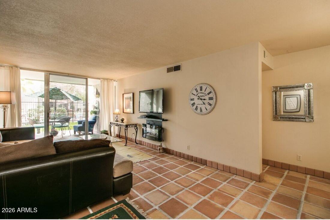 7625 East Camelback Road, Unit B117 Scottsdale, AZ 85251 - Photo 7 of 27 a living room with furniture a large window and a flat screen tv