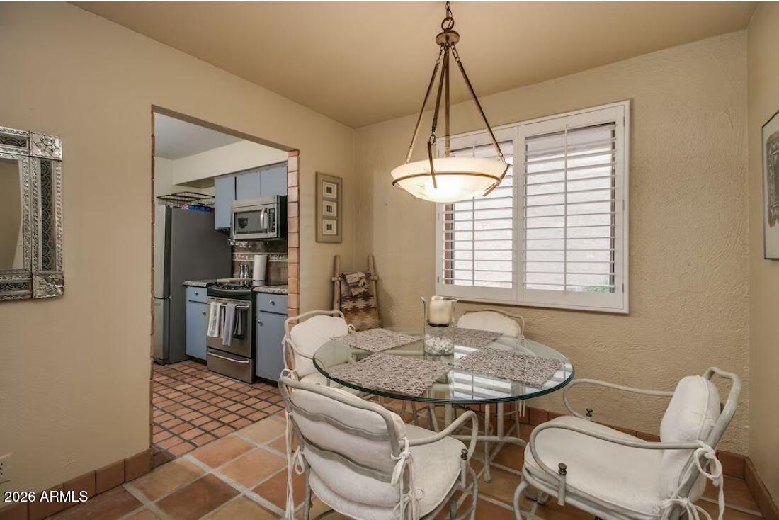 7625 East Camelback Road, Unit B117 Scottsdale, AZ 85251 - Photo 10 of 27 a kitchen with a dining table and chairs