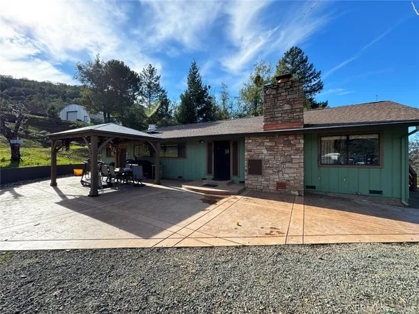 a view of a house with backyard sitting area and roof