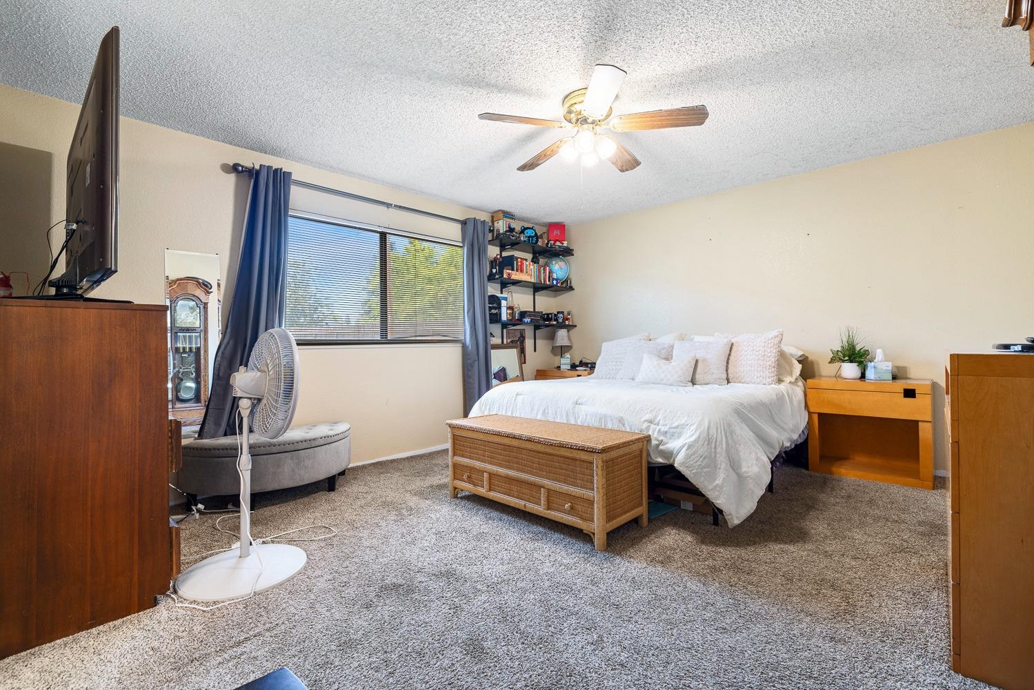 18800 Midland Way Madera, CA 93638 - Photo 15 of 27 a spacious bedroom with a bed and a chandelier