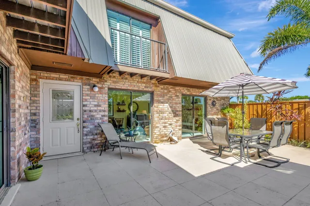 a view of a patio with a table and chairs under an umbrella