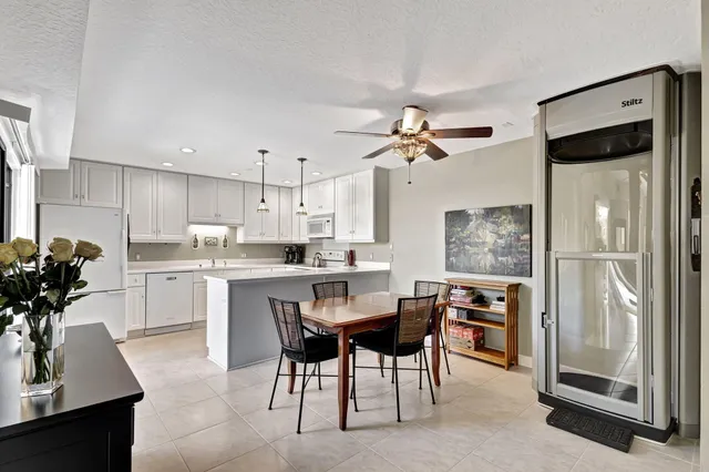 a kitchen with white cabinets and refrigerator
