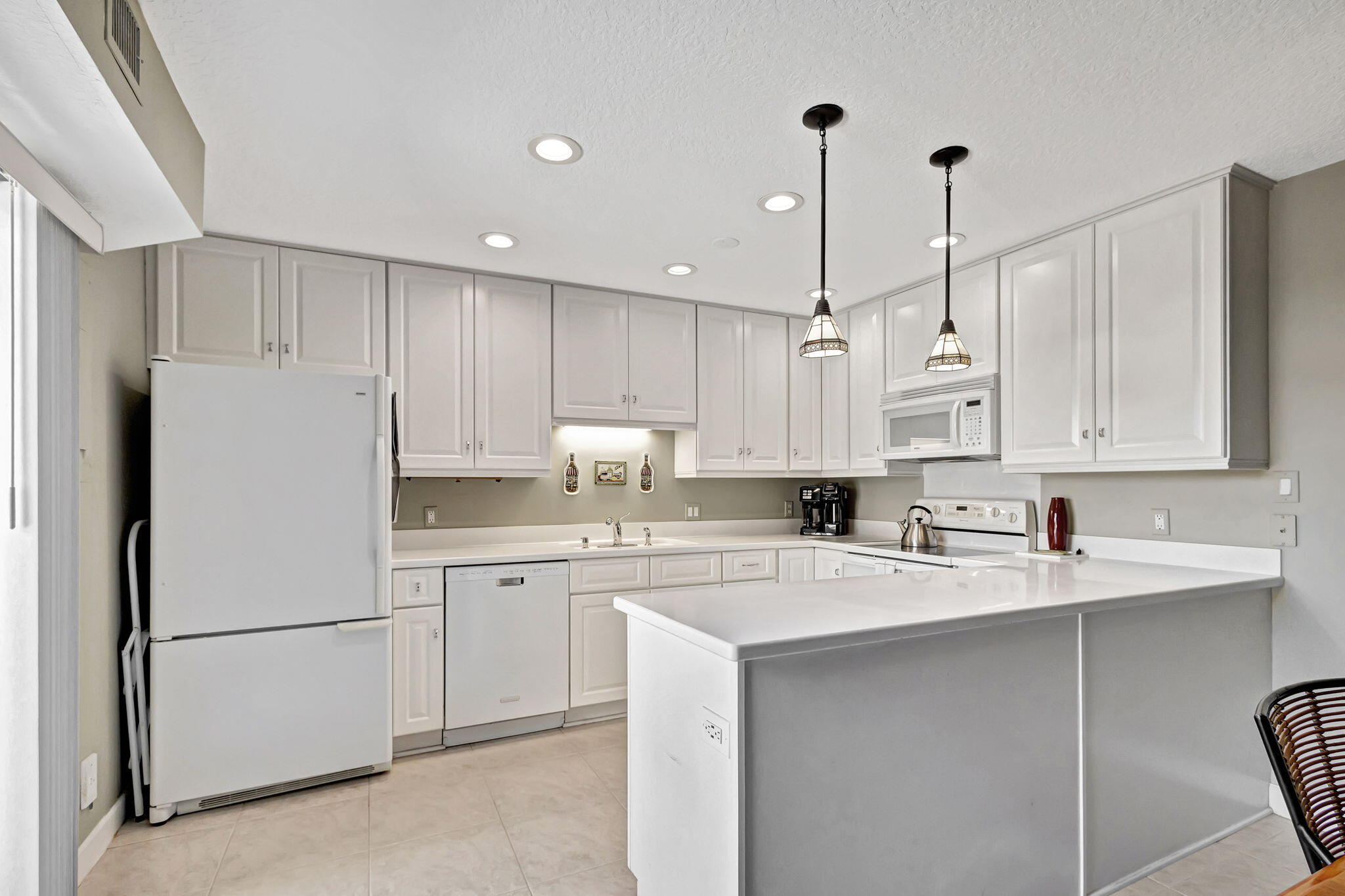 1420 Ocean Way, Unit 23B Jupiter, FL 33477 - Photo 9 of 37 a kitchen with white cabinets and white appliances