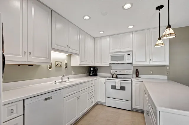 a kitchen with cabinets appliances a sink and a counter top space