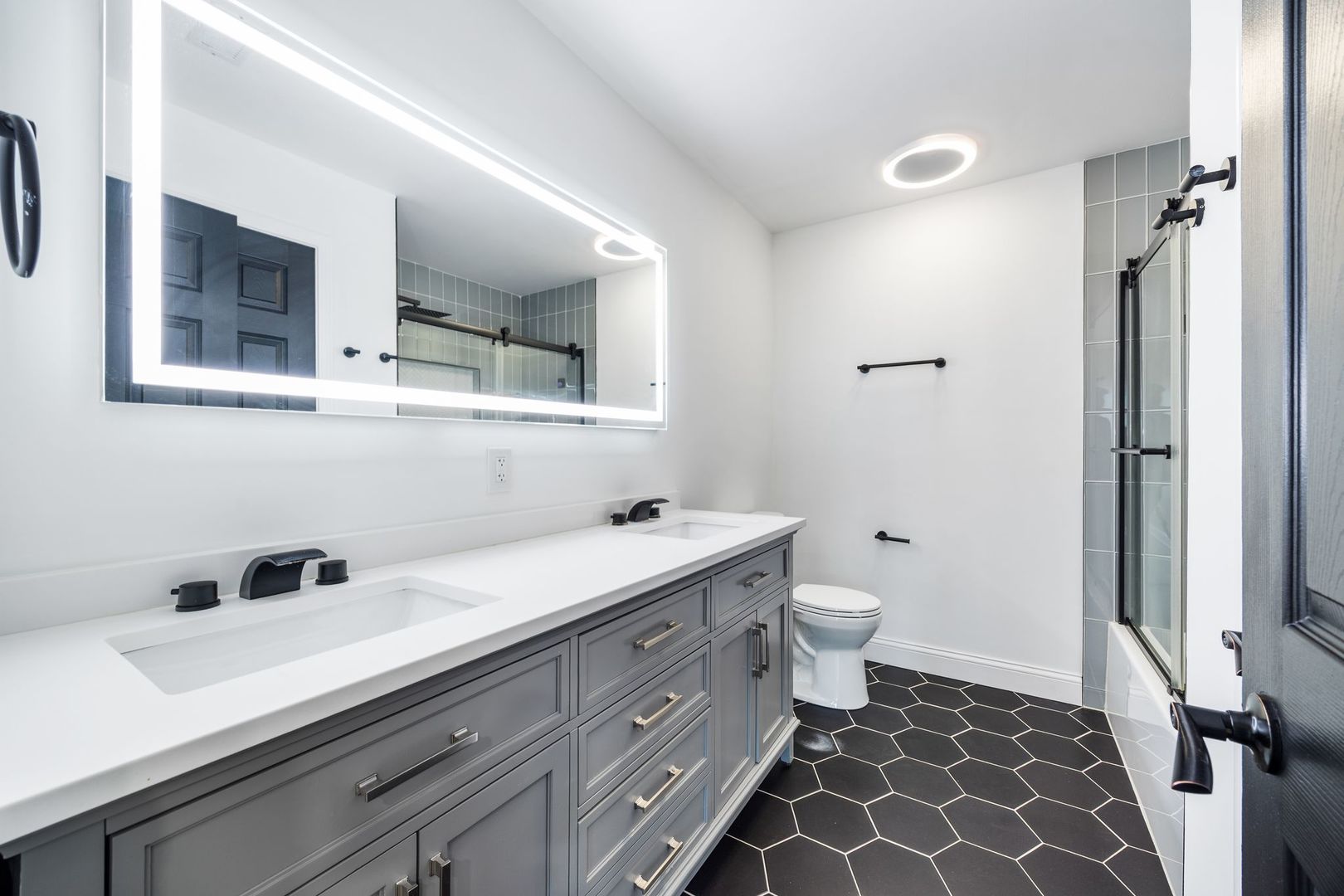 7730 Dempster Street, Unit 406 Morton Grove, IL 60053 - Photo 17 of 32 a bathroom with a double vanity sink toilet and mirror