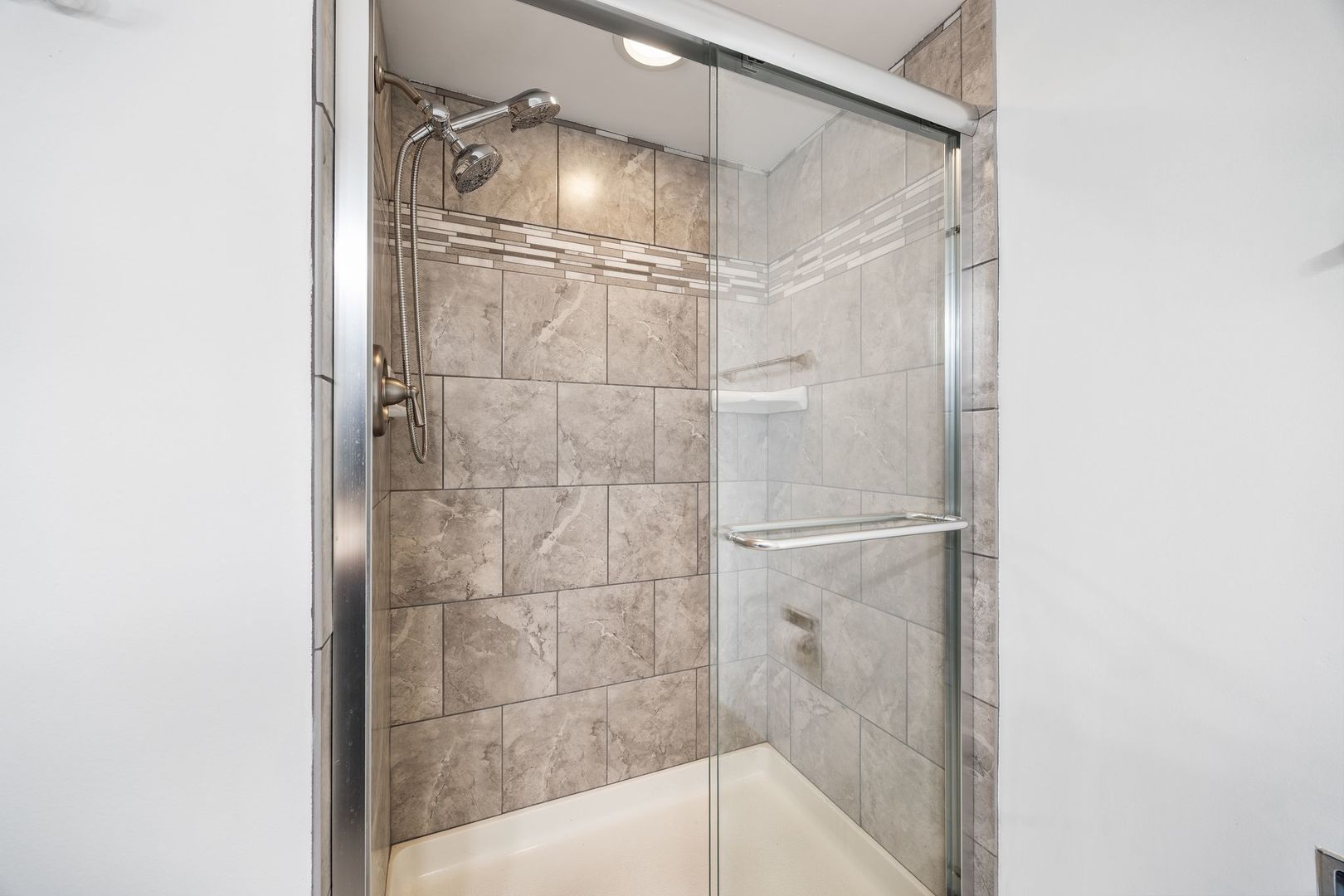 7730 Dempster Street, Unit 406 Morton Grove, IL 60053 - Photo 24 of 32 a bathroom with a glass shower door