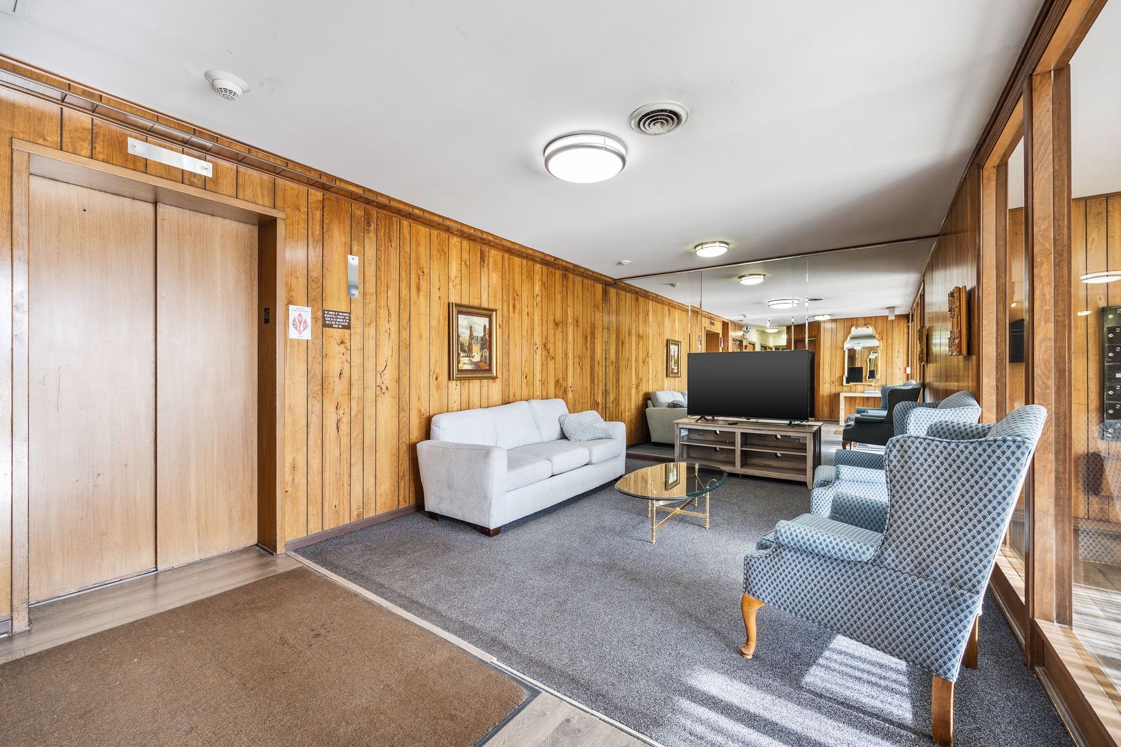 7730 Dempster Street, Unit 406 Morton Grove, IL 60053 - Photo 29 of 32 a living room with furniture and a flat screen tv