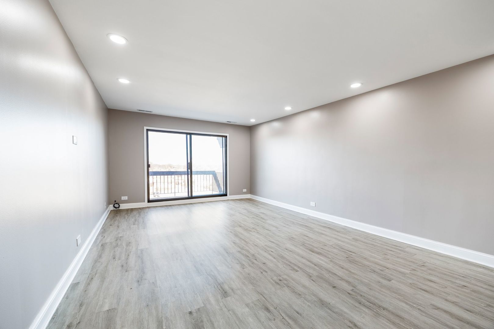 7730 Dempster Street, Unit 406 Morton Grove, IL 60053 - Photo 5 of 32 a view of an empty room with wooden floor and a window