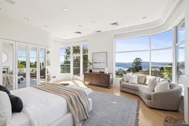 a spacious bedroom with a large window and a balcony