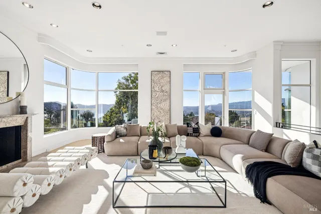 a living room with furniture large windows and a fireplace