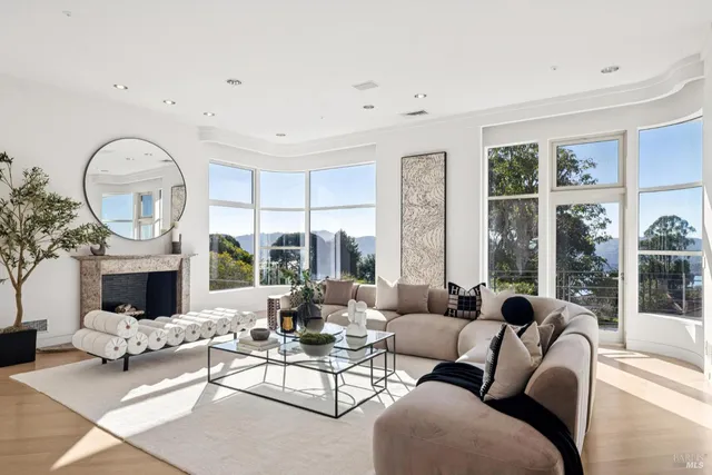 a living room with furniture a large window and a fireplace