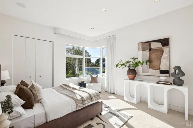 a bedroom with a bed and a large window