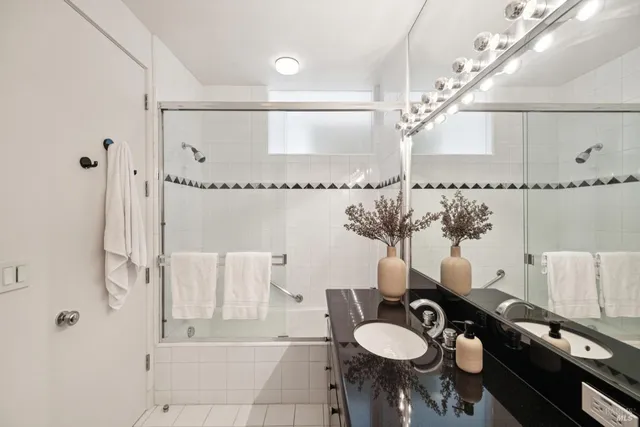 a bathroom with a tub shower and vanity