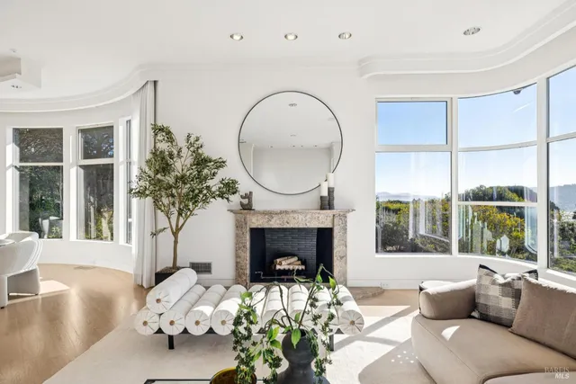 a living room with furniture fireplace and a large window