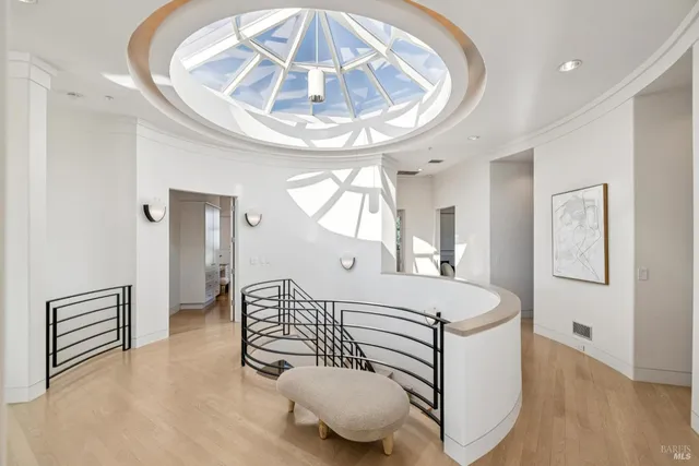 a living room with a bed a mirror and a chandelier