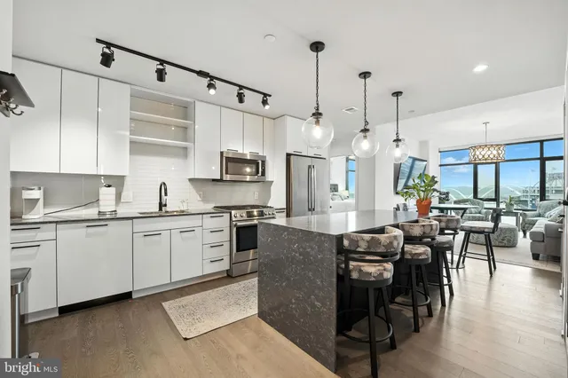 a large kitchen with granite countertop lots of counter top space and stainless steel appliances