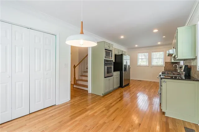 a kitchen with stainless steel appliances a refrigerator and a stove top oven