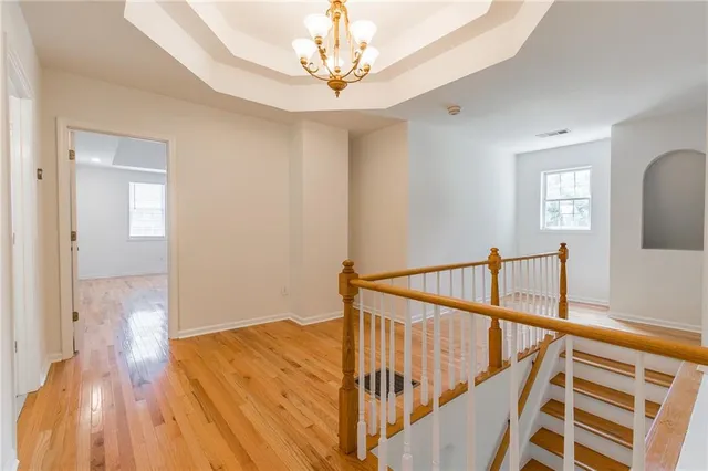 a view of a hallway with wooden floor and staircase