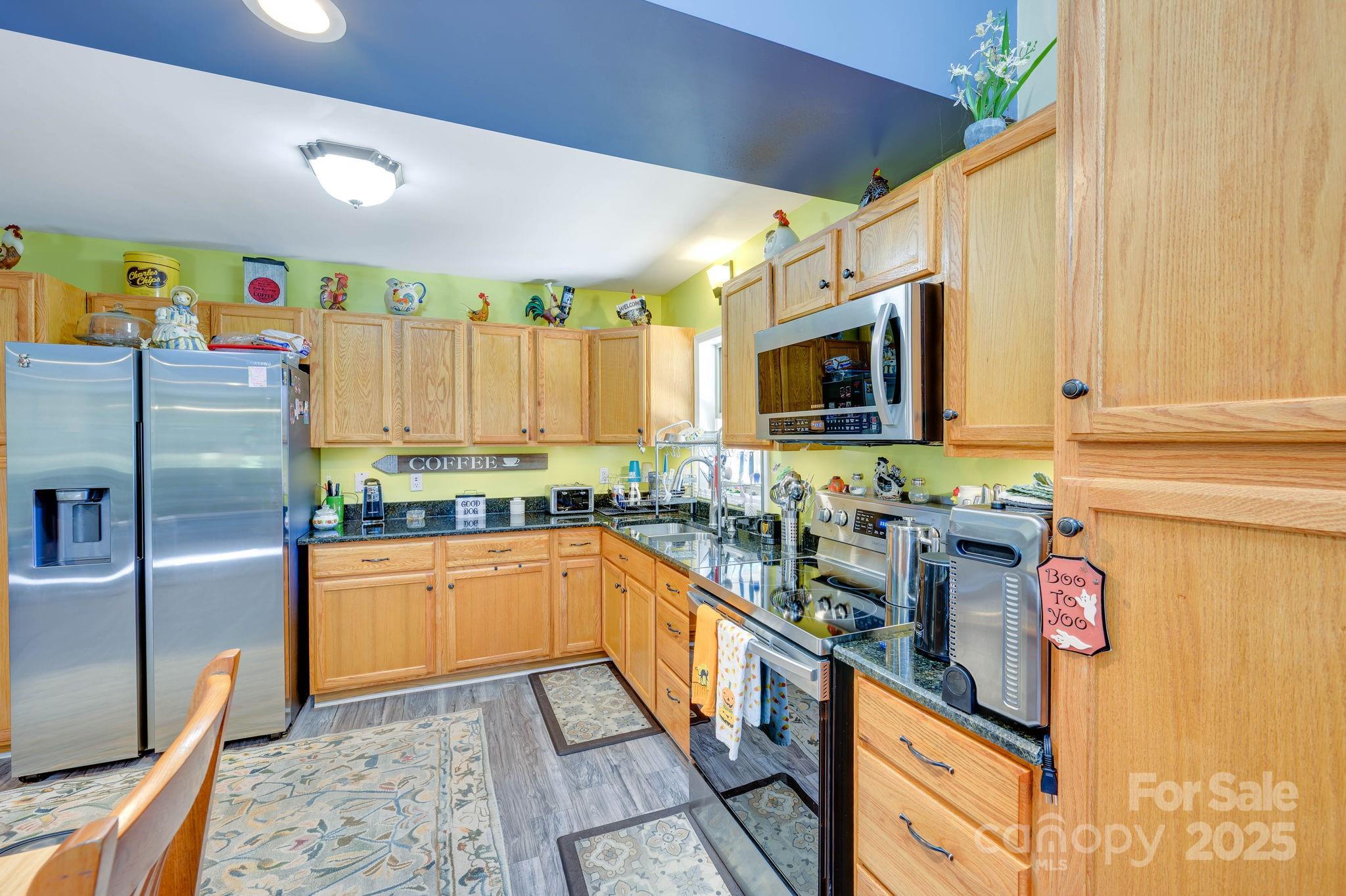 1390 Piney Knob Road Rutherfordton, NC 28139 - Photo 10 of 31 a kitchen with stainless steel appliances granite countertop a sink a stove a refrigerator a washer dryer and white cabinets
