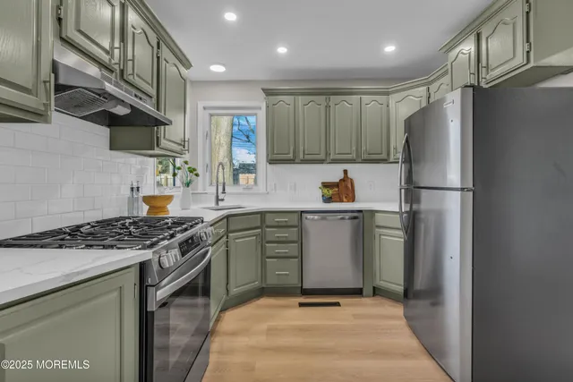 a kitchen with stainless steel appliances granite countertop a sink stove and refrigerator