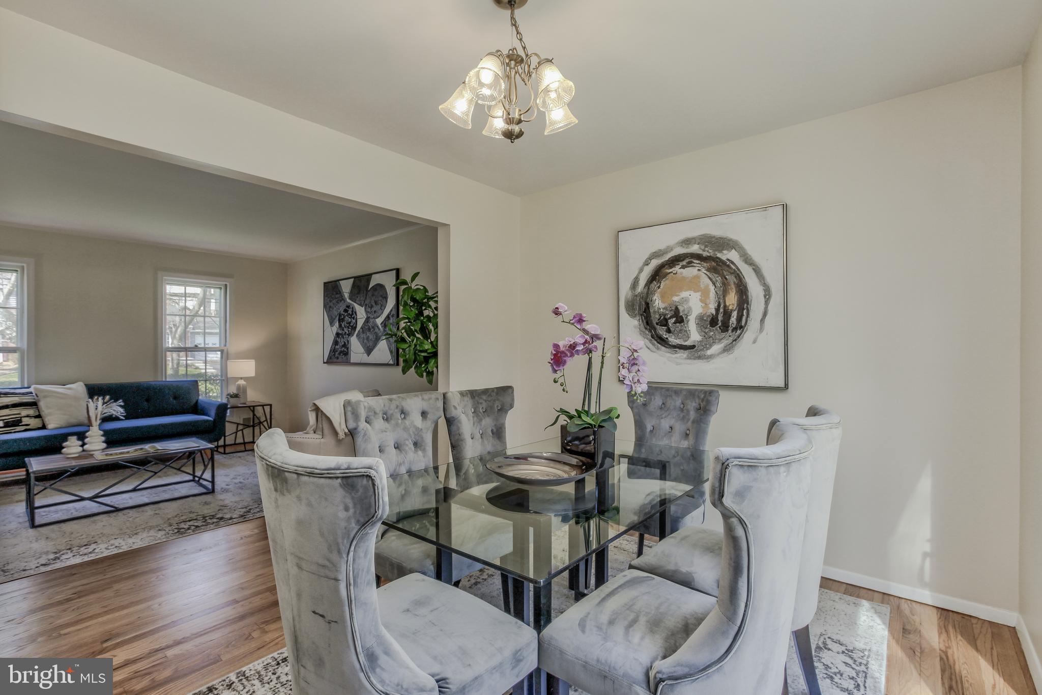14112 Flint Rock Road Rockville, MD 20853 - Photo 12 of 52 a dining room with wooden floor a chandelier a wooden table and chairs