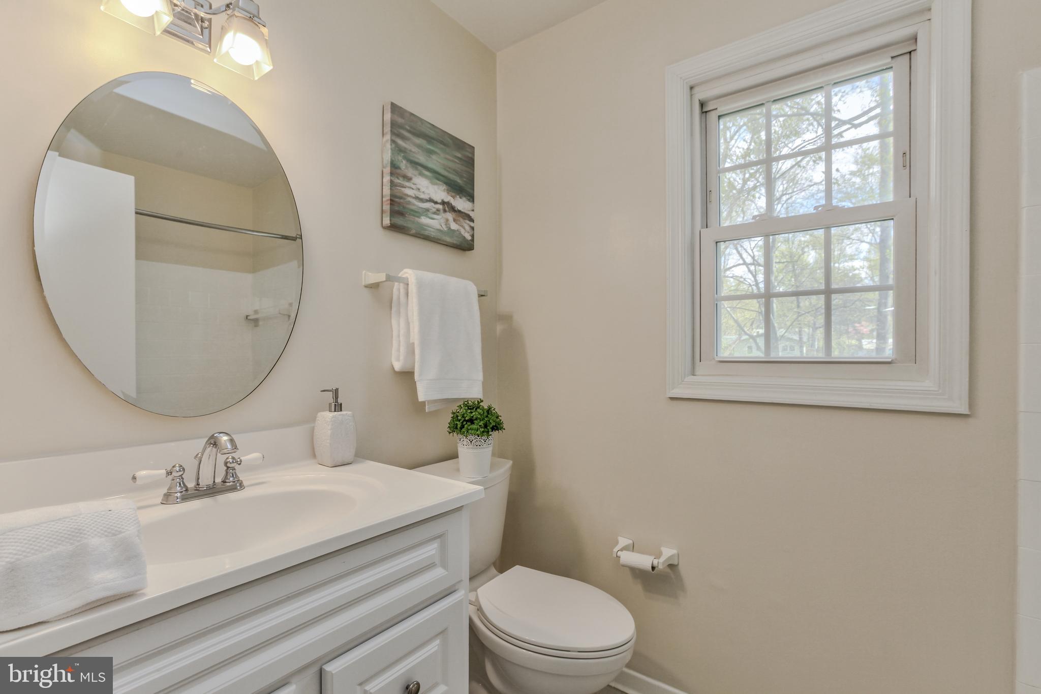 14112 Flint Rock Road Rockville, MD 20853 - Photo 34 of 52 a bathroom with a granite countertop toilet a sink and a mirror