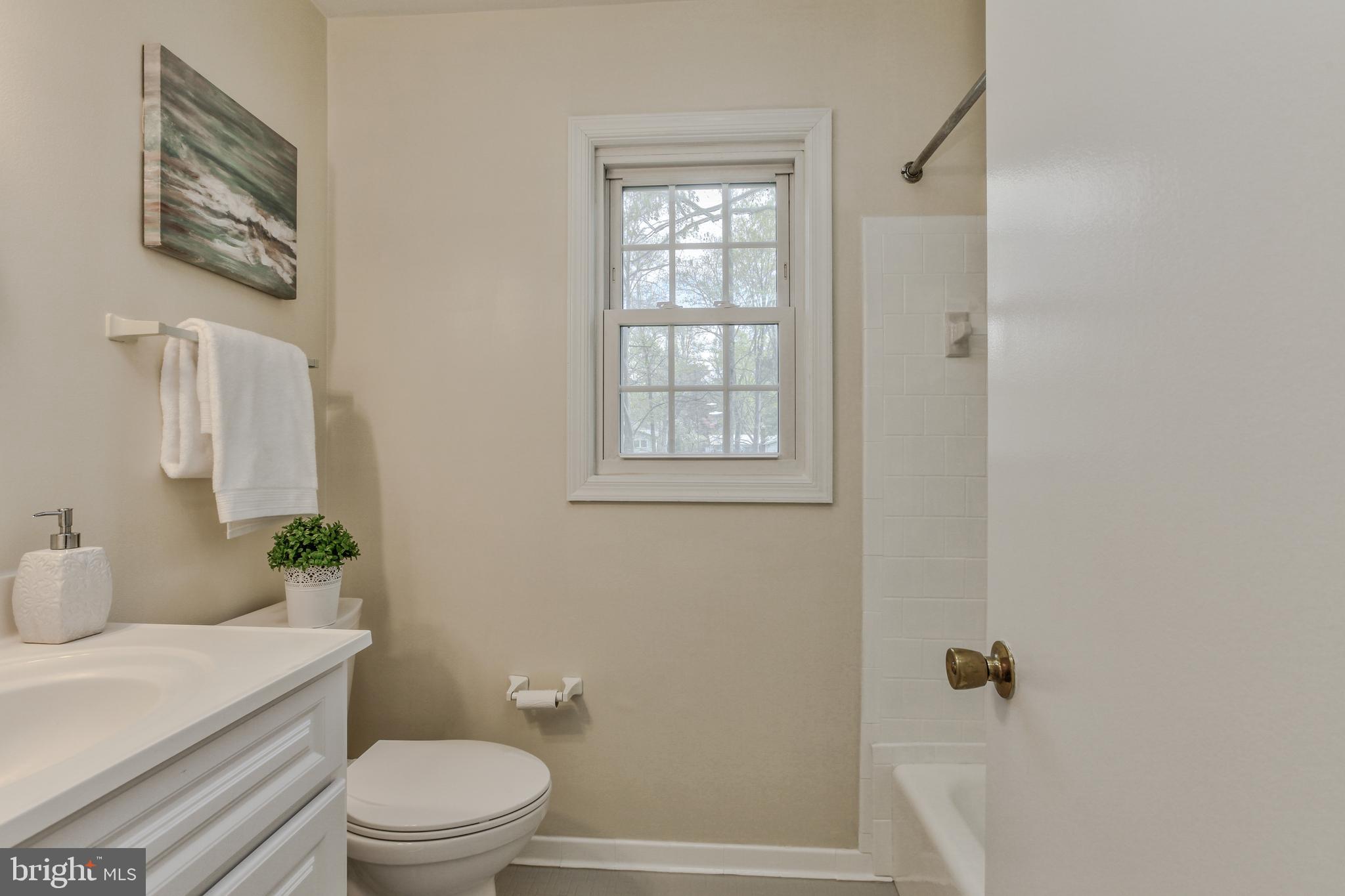14112 Flint Rock Road Rockville, MD 20853 - Photo 35 of 52 a bathroom with a granite countertop toilet a sink a mirror and shower