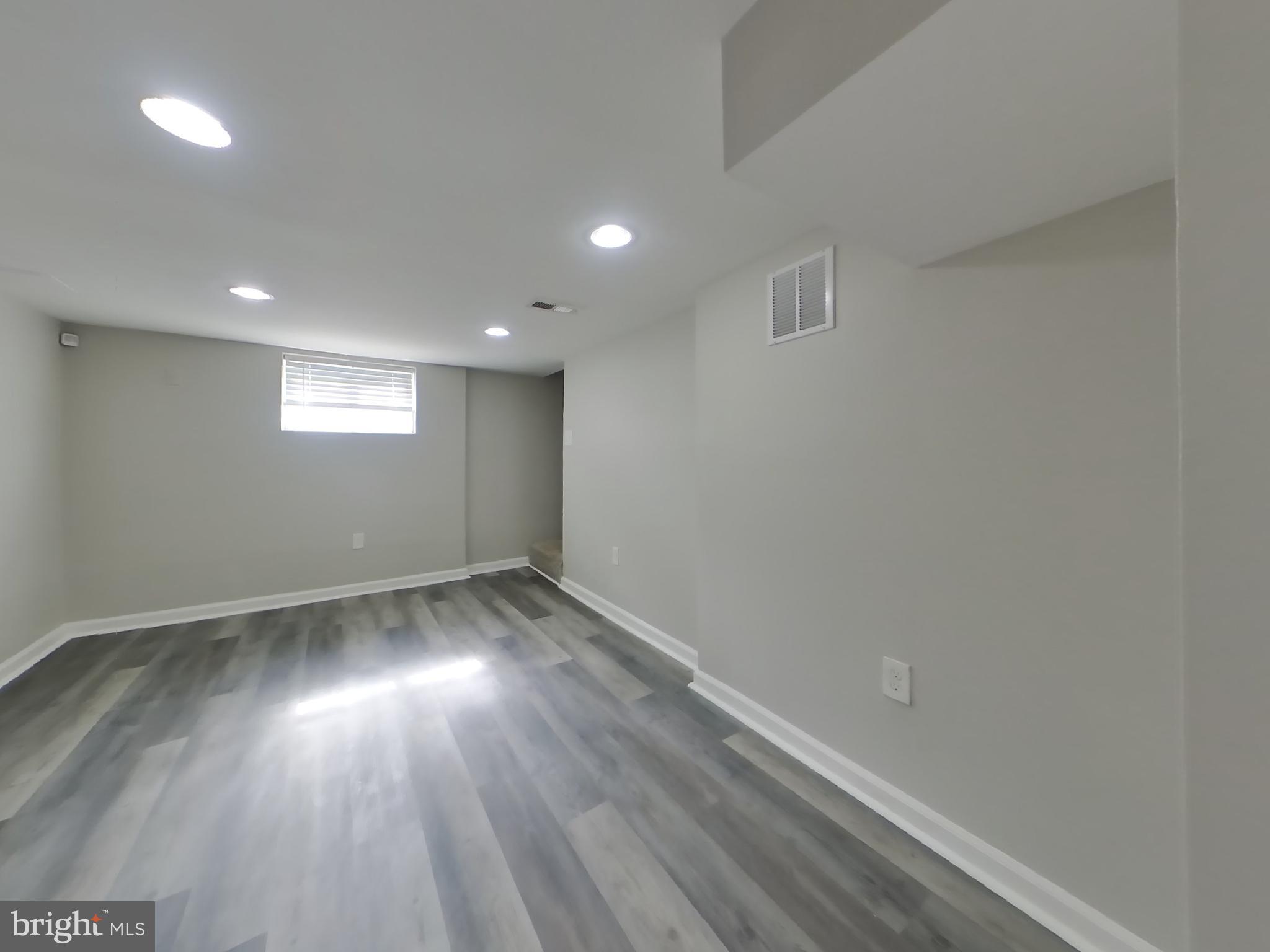 4217 Vine Street Capitol Heights, MD 20743 - Photo 13 of 15 an empty room with wooden floor and windows