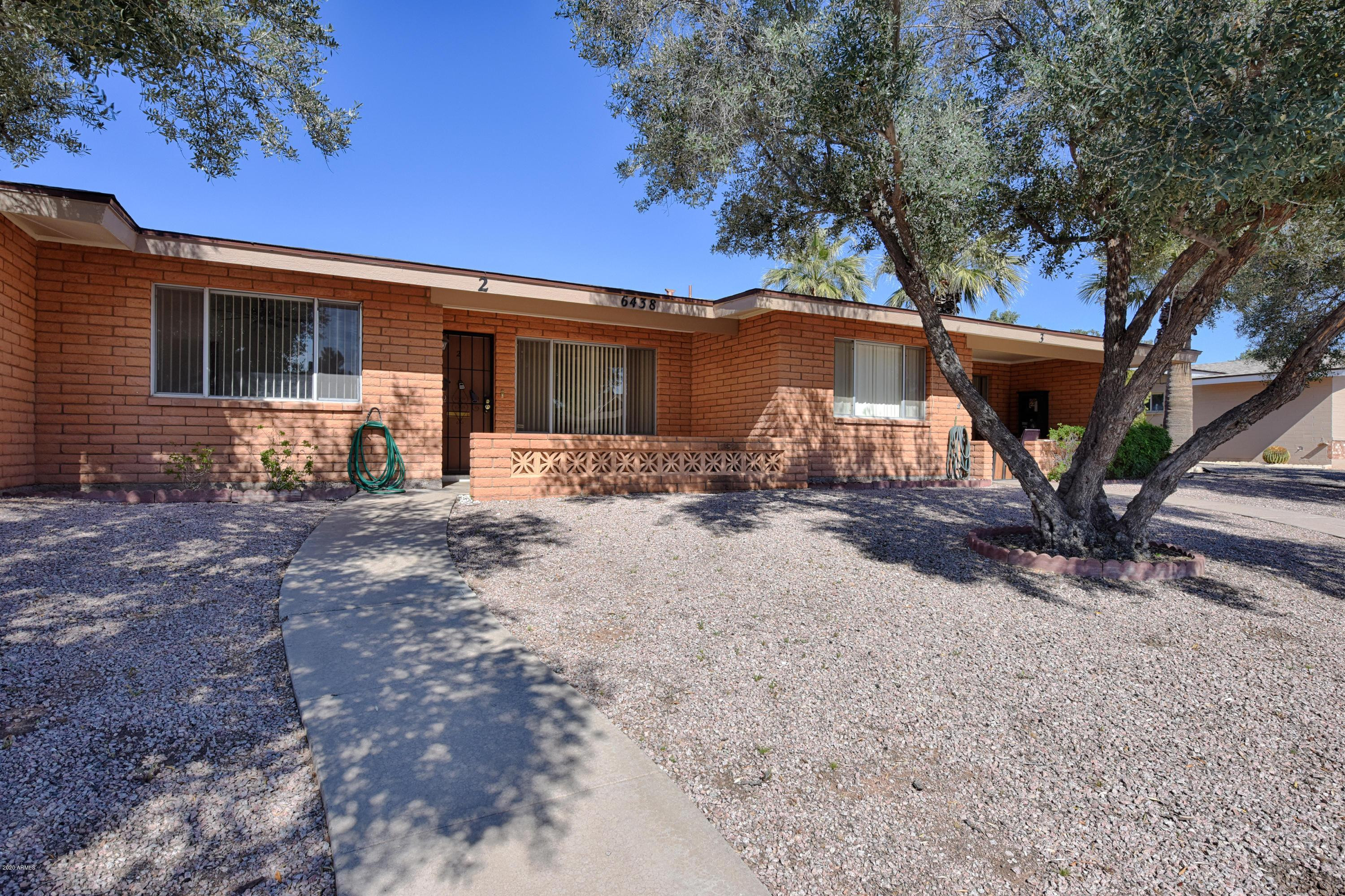6438 East Butte Street, Unit 2 Mesa, AZ 85205 - Photo 1 of 27 a front view of a house with yard tree and outdoor seating
