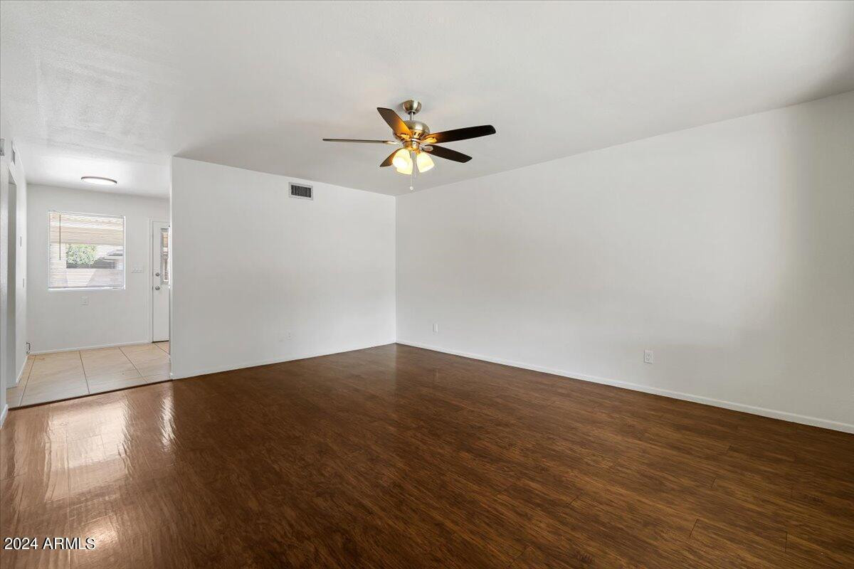 6438 East Butte Street, Unit 2 Mesa, AZ 85205 - Photo 7 of 27 an empty room with wooden floor and fan