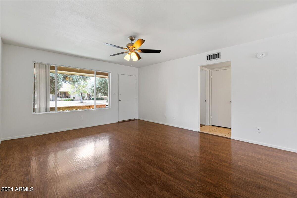 6438 East Butte Street, Unit 2 Mesa, AZ 85205 - Photo 9 of 27 a view of an empty room with a window and wooden floor