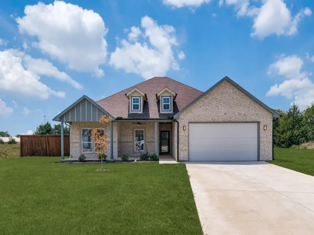 a front view of a house with a garden and yard