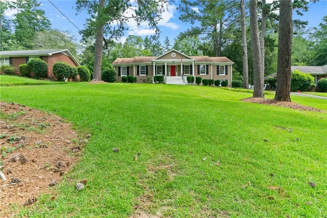 a view of a house with a yard and sitting area