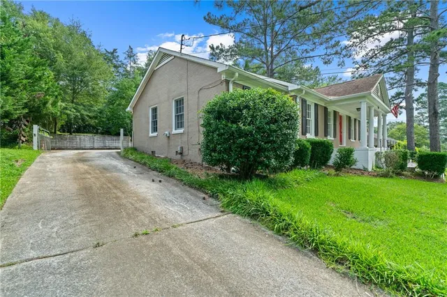 a view of house with a yard and potted plants