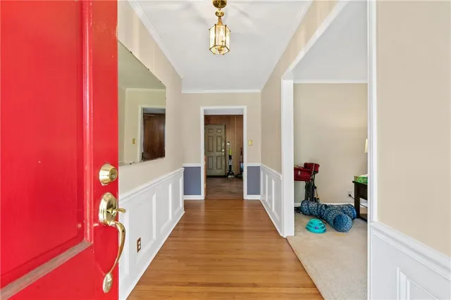 a view of a hallway with wooden floor and staircase