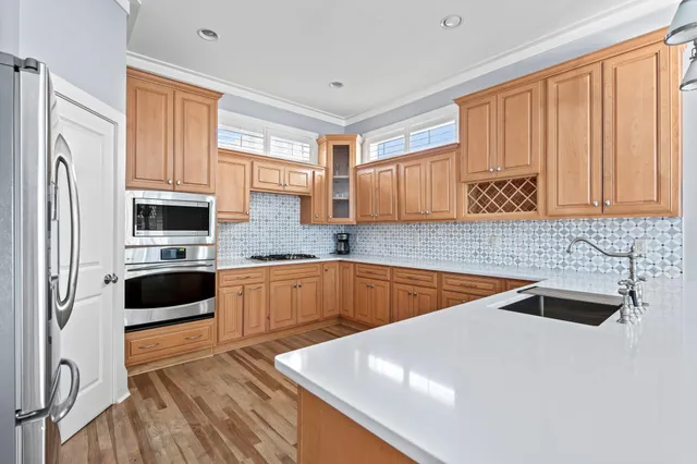 a kitchen with stainless steel appliances granite countertop a sink and a refrigerator