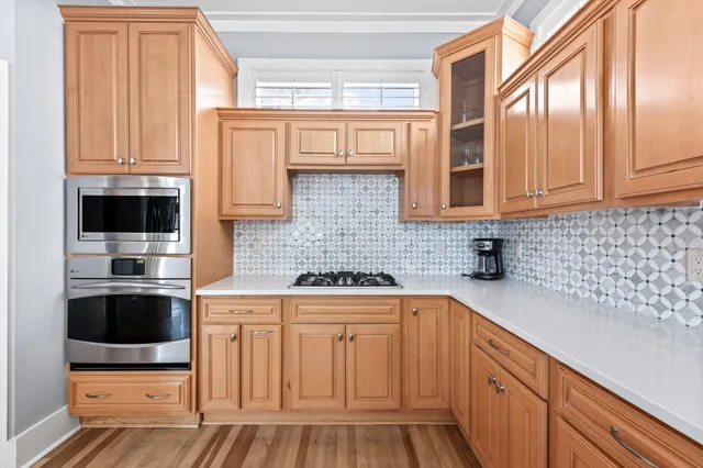 a kitchen with stainless steel appliances granite countertop a stove a sink and a microwave