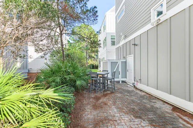 a view of a patio with table and chairs with wooden floor and fence
