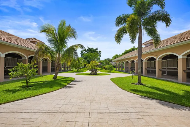 a view of a house next to a yard and large trees