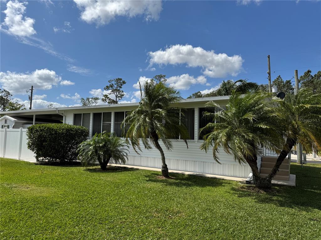 1385 Pine Island Drive St. Cloud, FL 34771 - Photo 16 of 28 a view of a house with a yard and potted plants