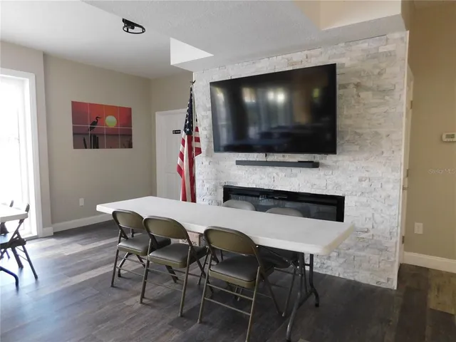 a living room with stainless steel appliances kitchen island granite countertop a sink and a microwave