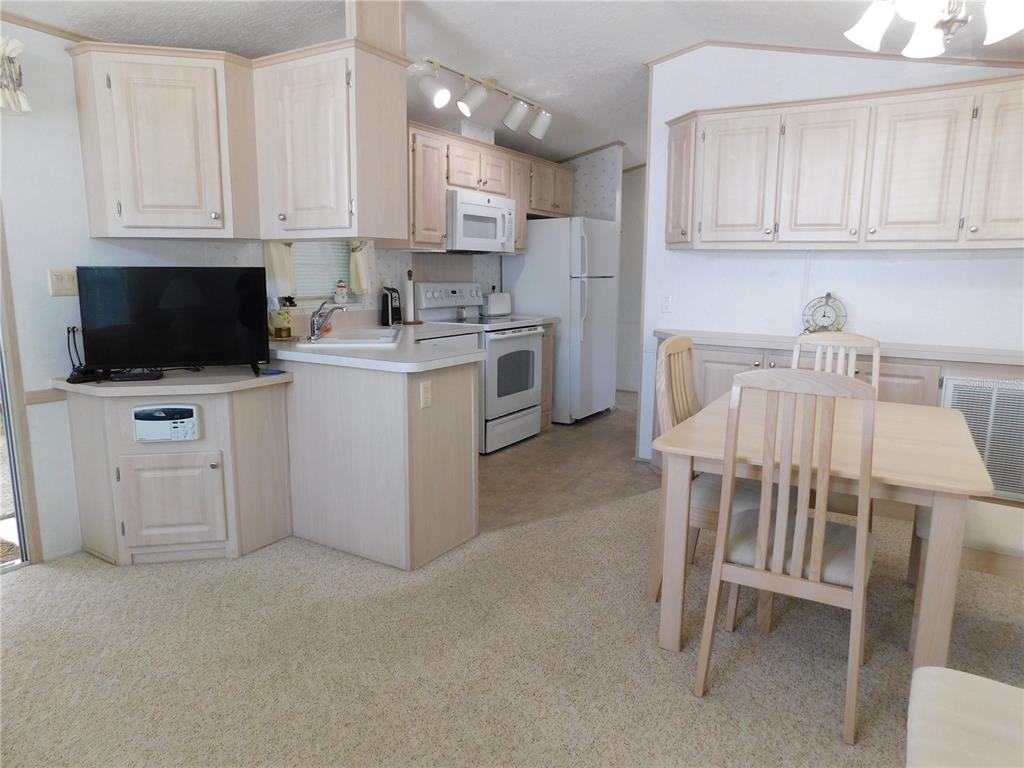 1385 Pine Island Drive St. Cloud, FL 34771 - Photo 9 of 28 a kitchen with white cabinets and stainless steel appliances