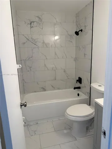 a bathroom with a toilet and a bath tub