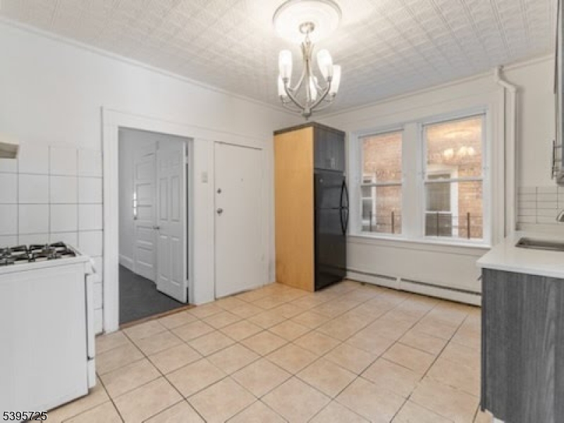 16 Tulip Street Passaic, NJ 07055 - Photo 7 of 7 a view of empty room with wooden floor and fan
