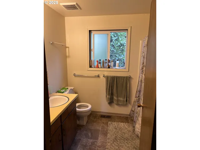 a bathroom with a granite countertop toilet and a sink