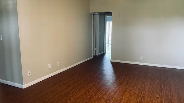 an empty room with wooden floor and closet