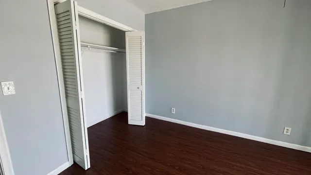 an empty room with wooden floor and closet